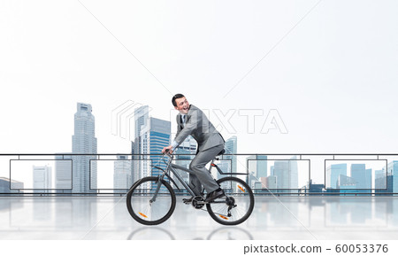 Man riding bicycle on penthouse balcony 60053376