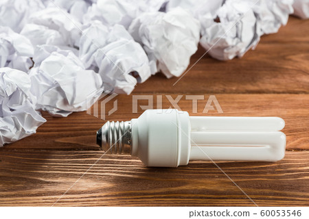 Ideological concept with wastepaper light bulb on wooden table Ideological concept with wastepaper light bulb on wooden table 60053546