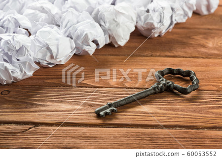 Concept of success and opportunity with old key among paperballs Concept of success and opportunity with old key among paperballs 60053552