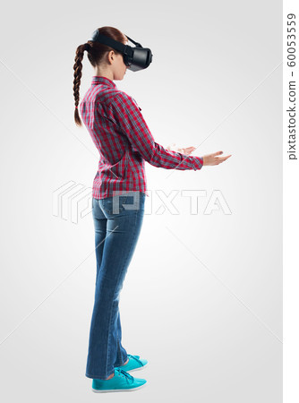Woman wearing VR headset and gesturing in air Woman wearing VR headset and gesturing in air 60053559
