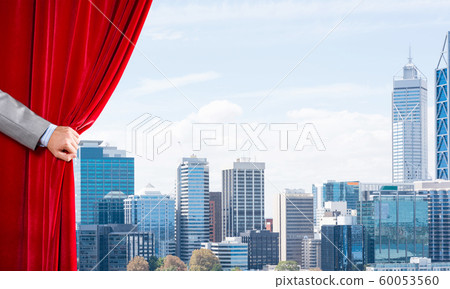 Modern business cityscape behind curtain opened by businessman hand 60053560