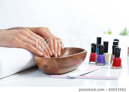 Closeup female hands in wooden bowl with water Closeup female hands in wooden bowl with water 60053562