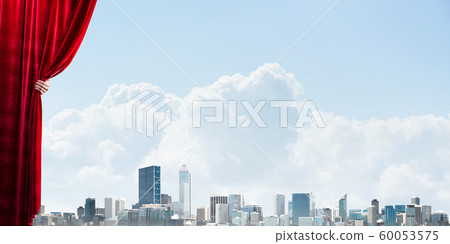 Business city behind red curtain and hand holding it 60053575