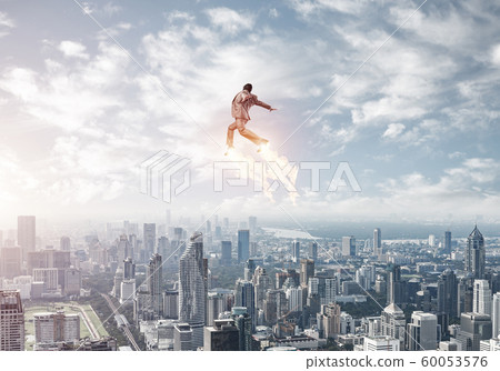 Businessman in suit and aviator hat flying in sky Businessman in suit and aviator hat flying in sky 60053576
