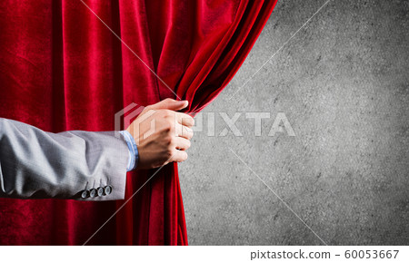 Concrete wall behind drapery curtain and hand opening it Concrete wall behind drapery curtain and hand opening it 60053667