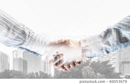 Business handshake as idea for unity and cooperation or greeting. Mixed media Business handshake as idea for unity and cooperation or greeting. Mixed media 60053679