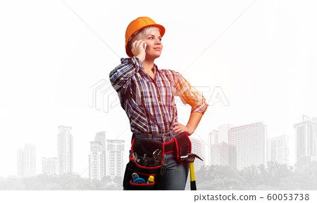 Attractive woman in workwear and hardhat Attractive woman in workwear and hardhat 60053738