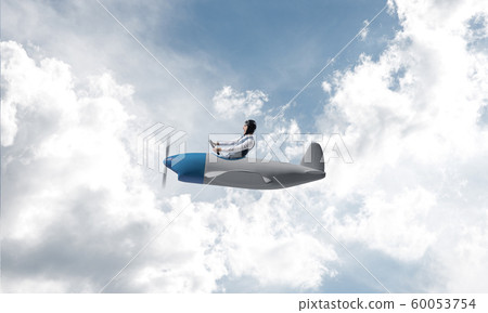 Man in aviator hat driving propeller plane 60053754
