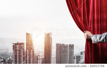 Modern business cityscape behind curtain opened by businessman hand Modern business cityscape behind curtain opened by businessman hand 60053786