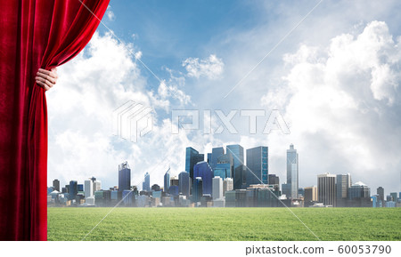 Green meadow behind red curtain and hand holding it Green meadow behind red curtain and hand holding it 60053790