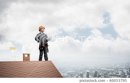Engineer in hardhat with technical blueprints Engineer in hardhat with technical blueprints 60053795