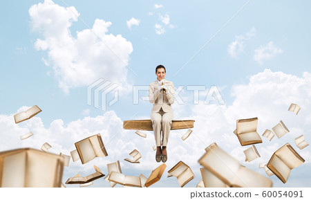 Attractive young woman playing trumpet on book Attractive young woman playing trumpet on book 60054091