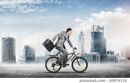 Man wearing business suit riding bicycle outdoor. Man wearing business suit riding bicycle outdoor. 60054116