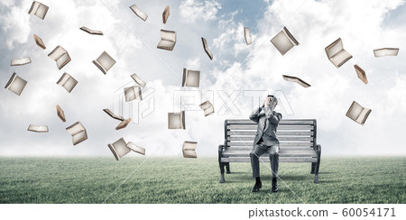 Young man in summer park on bench do not want to see anything 60054171