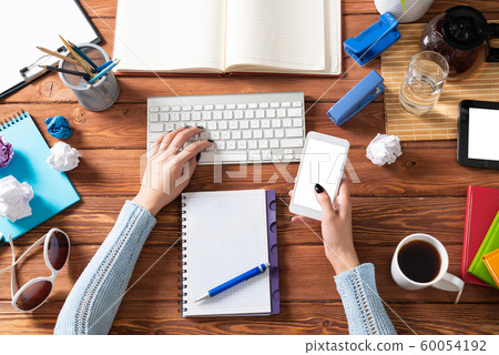 Business woman using smartphone at office desk Business woman using smartphone at office desk 60054192