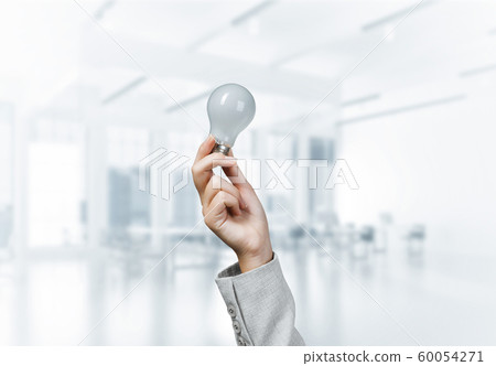 Woman hand holding glowing light bulb 60054271
