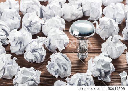 Ideological concept with wastepaper light bulb on wooden table Ideological concept with wastepaper light bulb on wooden table 60054299
