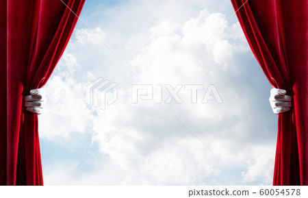Cloudy landscape behind red curtain and hand holding it Cloudy landscape behind red curtain and hand holding it 60054578
