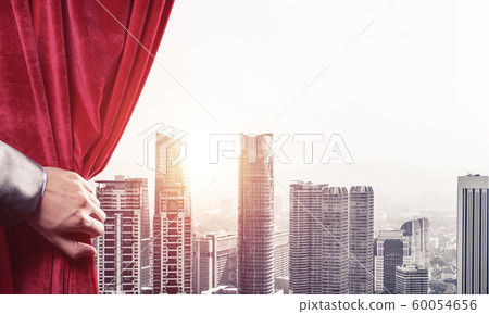 Modern business cityscape behind curtain opened by businessman hand 60054656
