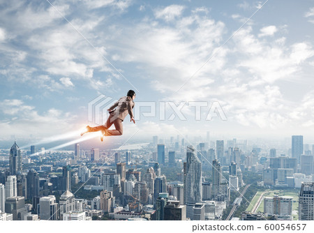 Businessman in suit and aviator hat flying in sky 60054657