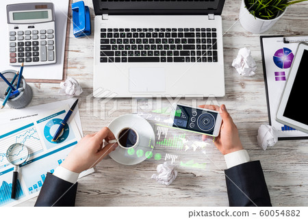 Businessman using smartphone at office desk Businessman using smartphone at office desk 60054882