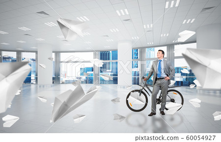 Young man wearing business suit with bike Young man wearing business suit with bike 60054927
