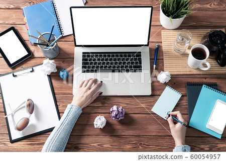 Woman writing in notebook with pen at desk Woman writing in notebook with pen at desk 60054957