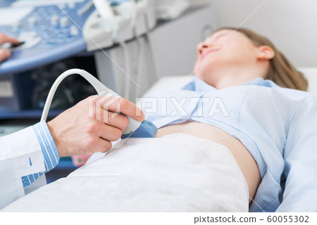 Doctor doing ultrasound screening checkup Doctor doing ultrasound screening checkup 60055302