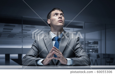 Handsome serious man with folded hands Handsome serious man with folded hands 60055306