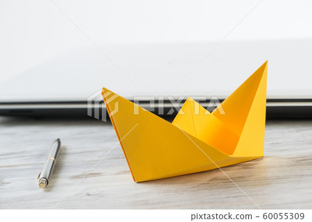 Businessman desk with yellow paper ship Businessman desk with yellow paper ship 60055309