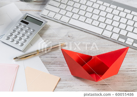 Businessman workspace at desk with red paper ship Businessman workspace at desk with red paper ship 60055486