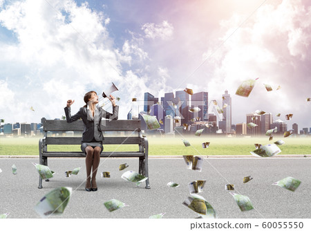 Young woman with megaphone on wooden bench Young woman with megaphone on wooden bench 60055550