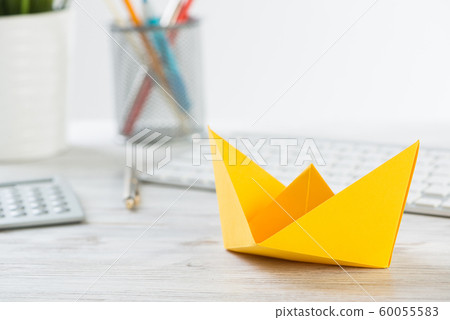 Workspace with office desk and yellow paper ship Workspace with office desk and yellow paper ship 60055583