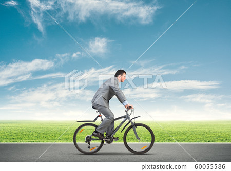Businessman commuting to work by bike Businessman commuting to work by bike 60055586