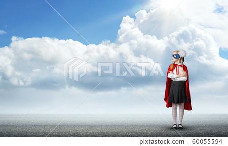Girl power concept with cute kid guardian against cloudscape background . Mixed media 60055594