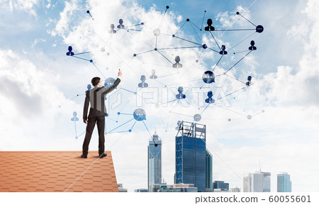 Businessman on house roof presenting networking and connection concept. Mixed media Businessman on house roof presenting networking and connection concept. Mixed media 60055601