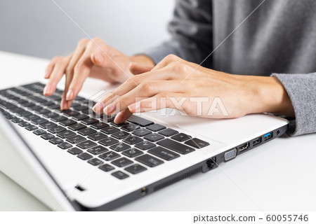 Student sitting at desk and working at laptop Student sitting at desk and working at laptop 60055746