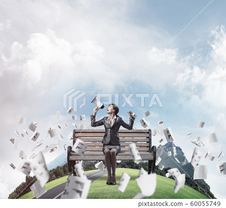 Business woman with megaphone on wooden bench Business woman with megaphone on wooden bench 60055749