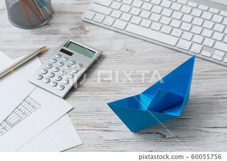 Modern office workspace with blue paper ship 60055756