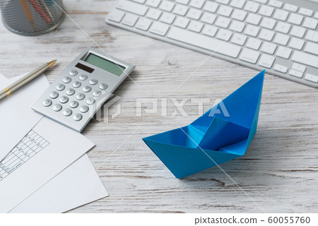 Office workspace with blue paper ship Office workspace with blue paper ship 60055760