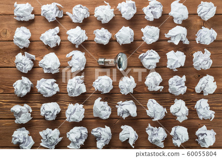 Ideological concept with wastepaper light bulb on wooden table Ideological concept with wastepaper light bulb on wooden table 60055804