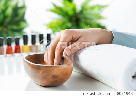 Closeup female hands in wooden bowl with water Closeup female hands in wooden bowl with water 60055948