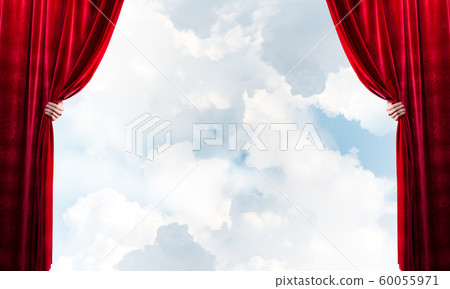Cloudy landscape behind red curtain and hand holding it Cloudy landscape behind red curtain and hand holding it 60055971