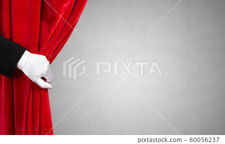 Concrete wall behind drapery curtain and hand opening it Concrete wall behind drapery curtain and hand opening it 60056237