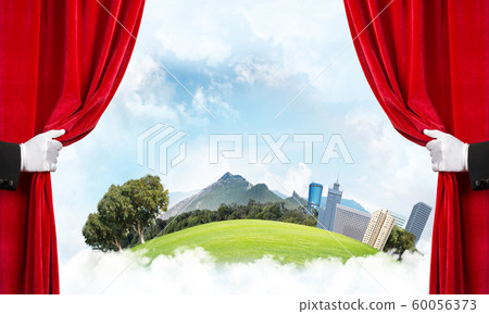 Modern cityscape behind drapery curtain and hand opening it 60056373