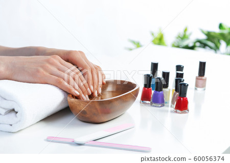 Closeup female hands in wooden bowl with water Closeup female hands in wooden bowl with water 60056374