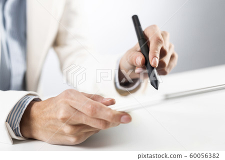 Man in business suit using tablet computer. Man in business suit using tablet computer. 60056382