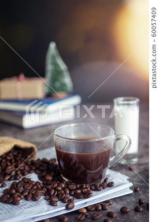 a cup of hot espresso coffee drink with smoke and roasted coffee beans on the table in the morning. vertical image, cropped shot a cup of hot espresso coffee drink with smoke and roasted coffee beans on the table in the morning. vertical image, cropped shot 60057409