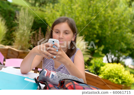Pre teenager girl texting on mobile phone Pre teenager girl texting on mobile phone 60061715