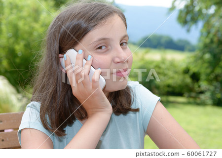 smiling pre teenager girl calling on smartphone, smiling pre teenager girl calling on smartphone, 60061727